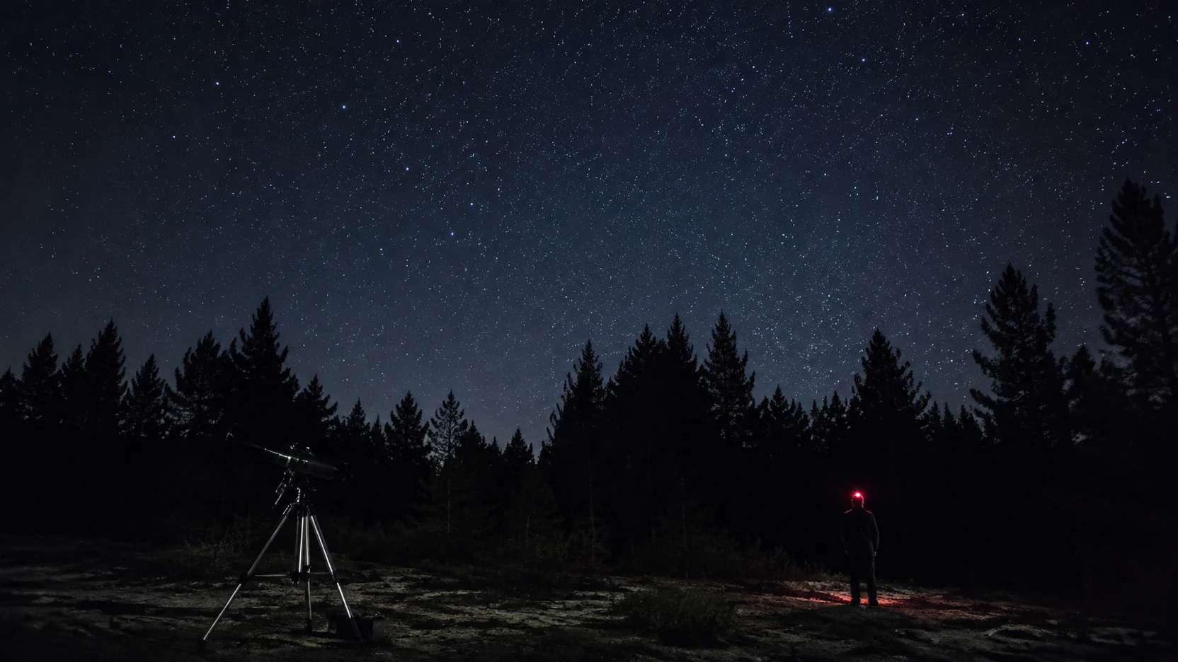 Observación de estrellas: telescopio montado en un claro bajo un cielo nocturno despejado