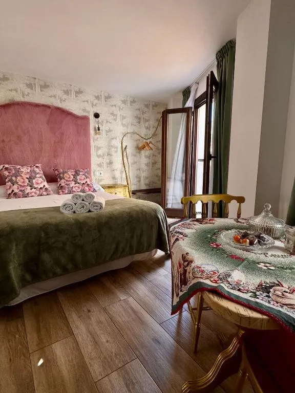 Dormitorio de ATENEO CUENCA con cama y mesa junto a una pared de piedra