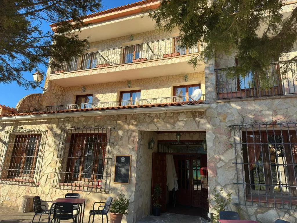 Fachada del Hotel Restaurante Río Cuervo rodeada de árboles en Vega del Codorno