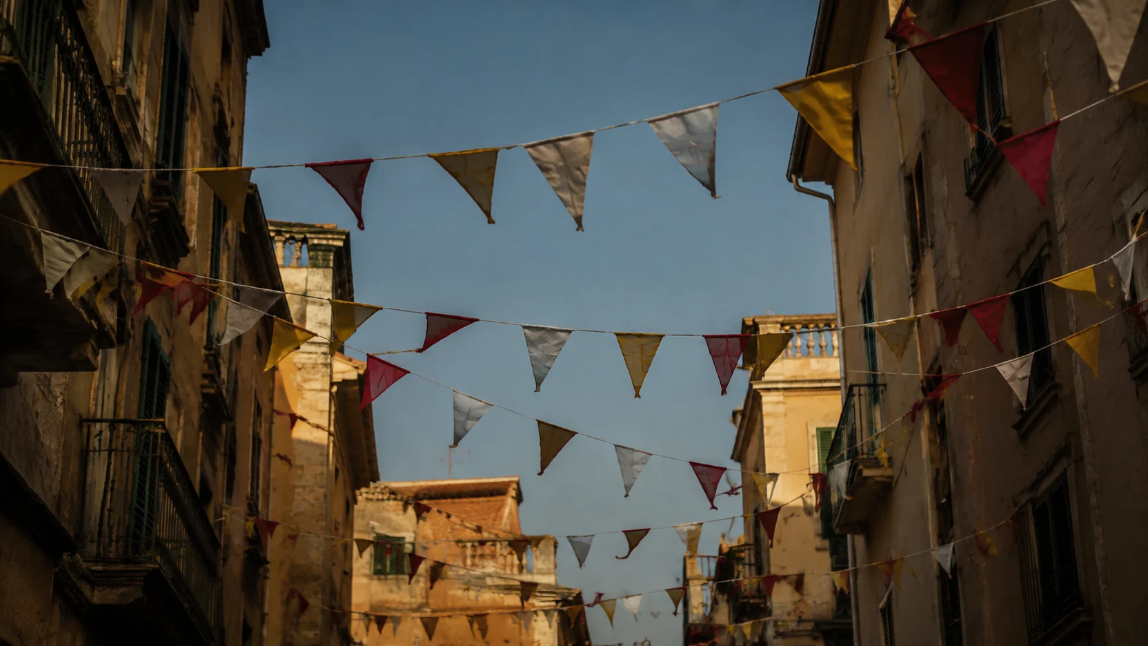 Fiestas de Cuenca: banderines de papel cruzando una calle estrecha al final de la tarde