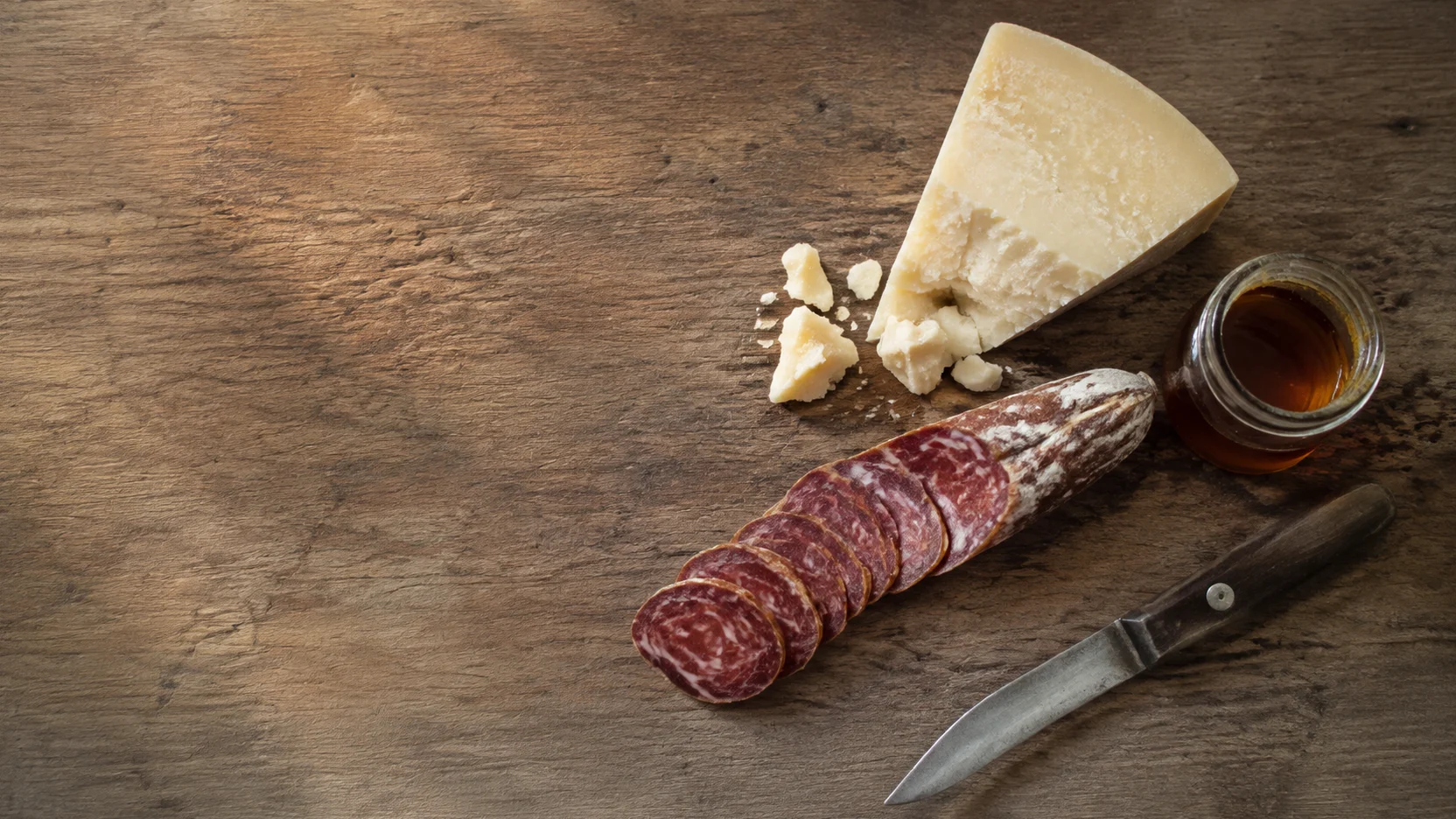 Productos típicos de Cuenca: tabla de madera con embutido, queso curado y un tarro de miel