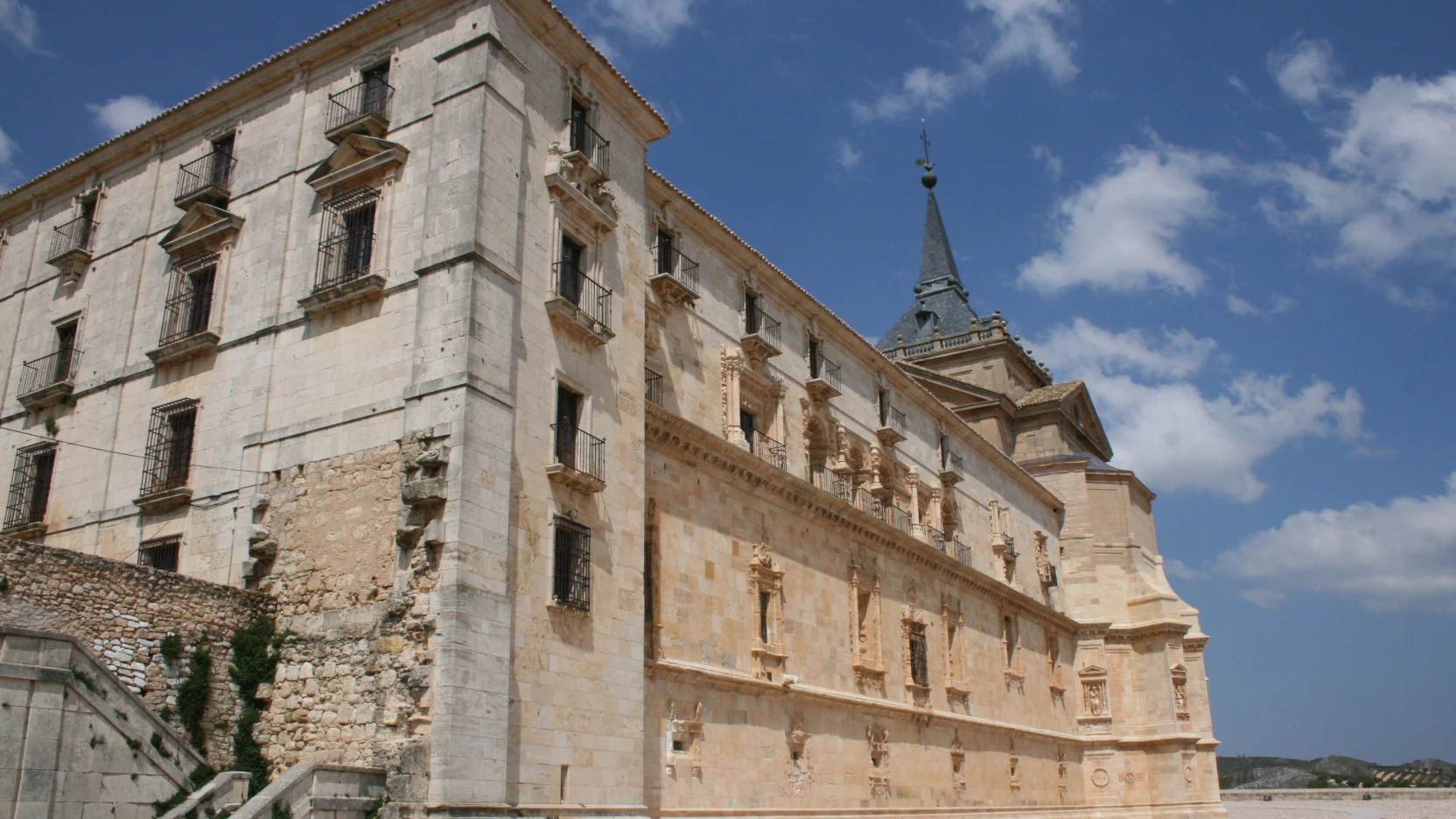 Fachada monumental de un monasterio renacentista sobre un cerro manchego