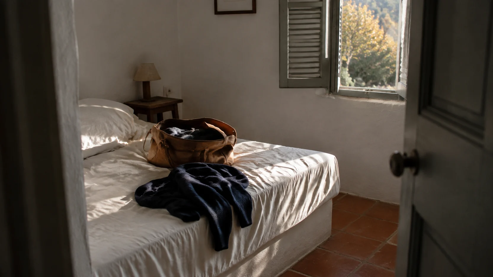 Fin de semana en Cuenca: bolsa de viaje sobre una cama en una habitación encalada