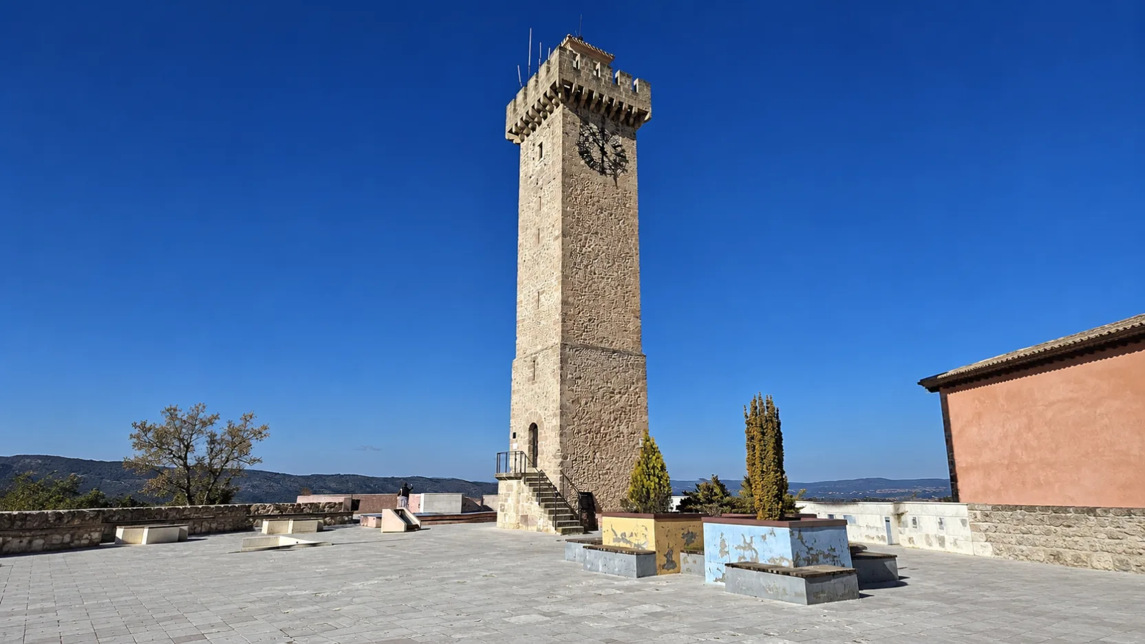 Torre de Mangana, la torre del reloj de Cuenca, sola en su explanada de piedra a mediodía