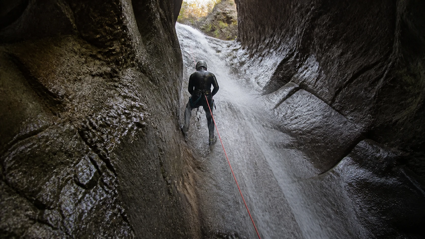 Barranquismo en Cuenca: rápel por una pared mojada dentro de un barranco estrecho