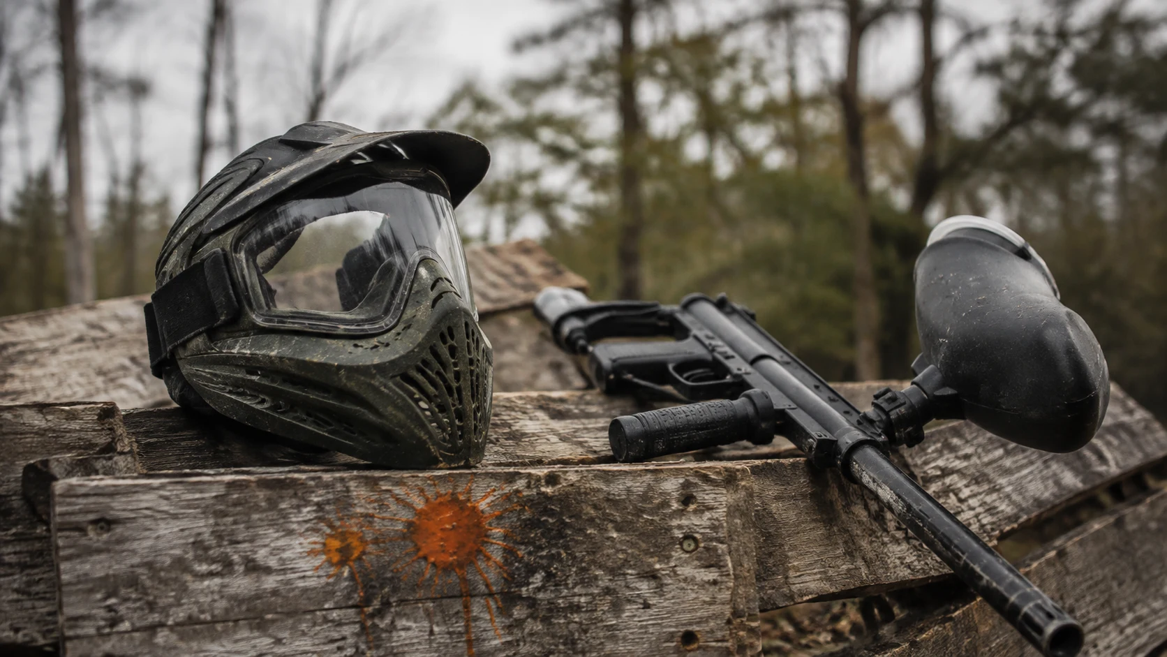 Paintball en Cuenca: máscara y marcadora apoyadas en un parapeto de madera